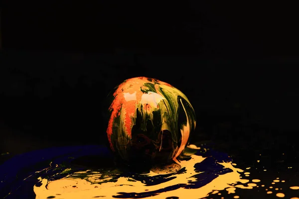 Paint splashing on orange fruit. Nutrition and food art concept.