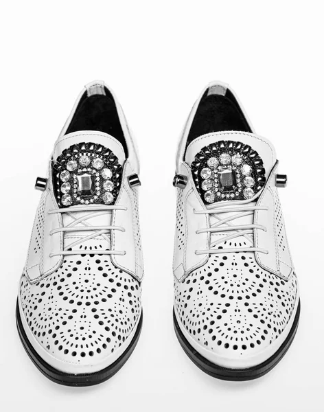 Shoes made out of white leather on white background, isolated. Footwear for women on flat sole with perforation and rhinestones. Pair of fashionable comfortable oxfords shoes. Female footwear concept — Stock Photo, Image
