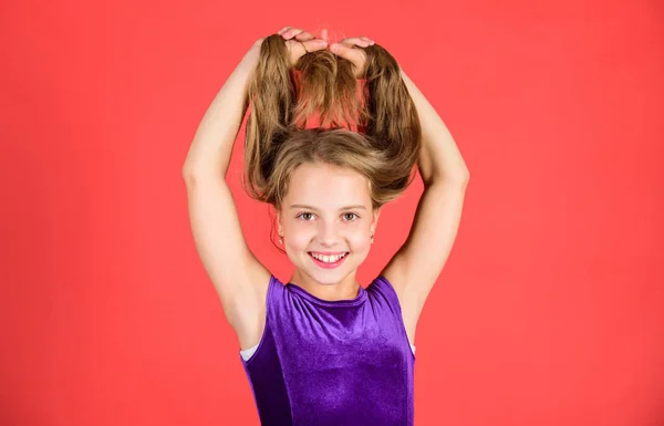 How to make tidy hairstyle for kid. Ballroom latin dance hairstyles. Kid girl with long hair wear dress on red background. Things you need know about ballroom dance hairstyle. Hairstyle for dancer