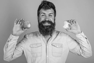 Elma her gün yemek. Meyve sağlıklı yemek saati her zaman iyi bir fikir. Adam yakışıklı hipster uzun sakal olgun elma ve neredeyse yenmiş elma güdük tutar. Mükemmel ve kavramı kusur. Adam diyet beslenme meyve yiyor