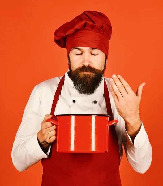 Koken met dromerig gezicht in bordeaux uniform ruikt soep — Stockfoto