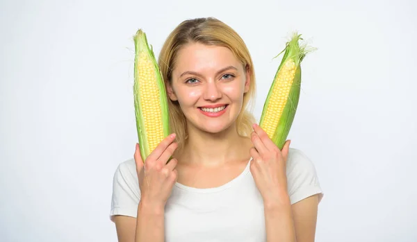 Жінка тримає жовтий кукурудзяний коб на білому тлі. Дівчина грайливий настрій тримає стиглі кути в руках. Їжа вегетаріанський і здоровий натуральний органічний продукт. Приготувати кукурудзяний рецепт. Концепція вегетаріанського харчування — стокове фото