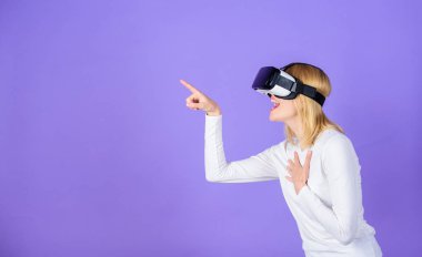 Kız kullanım modern teknoloji vr kulaklık. Dijital aygıt modern fırsat. Büyüleyici etkileşim sanal gerçeklik. Kadın başa takılı ekran menekşe arka plan. Sanal gerçeklik ve geleceğin teknolojisi.