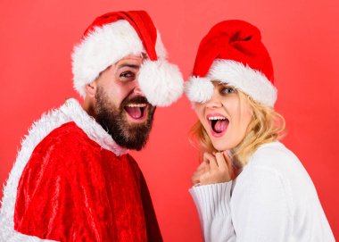 Çift kutlamak kış tatil Noel partisi. Noel maskeli balo karnival kavramı. Çift neşeli yüzü Noel kutlaması. Sakal ve kadın santa şapka kırmızı arka planı olan adam. Noel Baba kostüm Kiralama