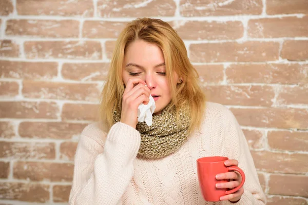 Los remedios deben ayudar a vencer el frío rápido. La mujer se siente muy mal estornudando. Chica en bufanda sostener taza de té y tejido. Goteo nasal y otros síntomas de resfriado. Consejos cómo deshacerse del frío. Remedios contra el resfriado —  Fotos de Stock
