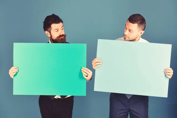 जिज्ञासू चेहरे असलेले व्यावसायिक हिरव्या आणि गुलाबी चिन्ह बोर्ड सादर करतात — स्टॉक फोटो, इमेज