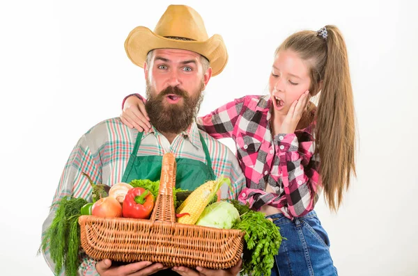 Man bearded rustic farmer with kid. Family farm organic vegetables. Farmers family homegrown harvest. Gardening and harvesting. Father farmer or gardener with daughter hold basket harvest vegetables