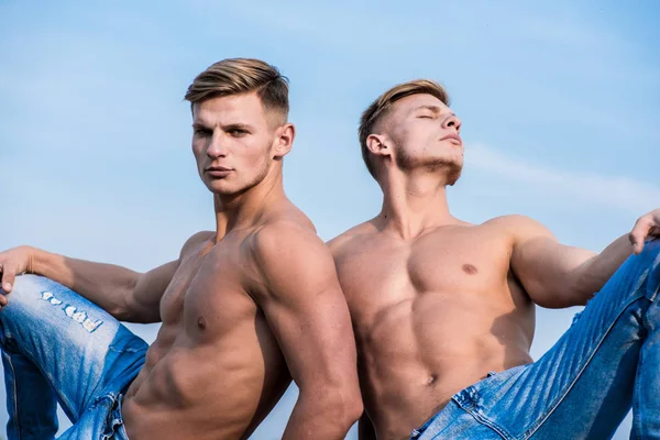 Attractive twins relaxing. Men muscular chest naked torso sky background. Masculinity and sexuality. Men muscular athlete bodybuilder relaxing lean each other. Sexy torso attractive body strong macho