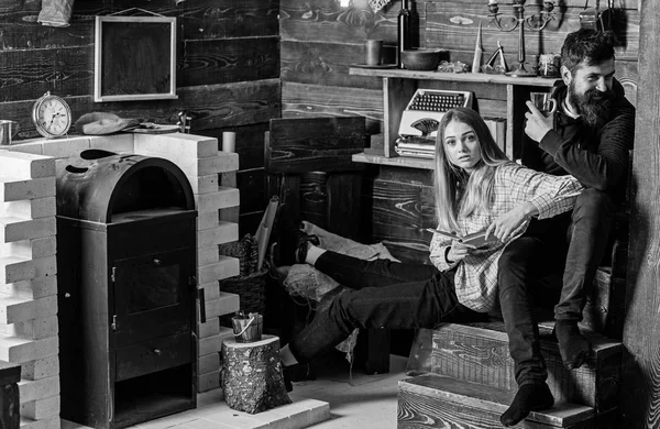 Pareja pasar la noche agradable con libro y vino caliente, fondo interior de madera. Concepto de noche conmovedor. Pareja de vacaciones en el bosque. Chica y el hombre en caras relajadas disfrutar de un ambiente cálido — Foto de Stock