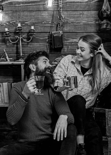 Pareja enamorada hablando en ambiente romántico, fondo de madera. Pareja pasar una agradable noche acogedora con bebidas calientes. Hombre y mujer hablando mientras sostienen el vaso o taza con vino caliente. Concepto romántico — Foto de Stock