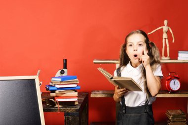 Fikir olan kız öğrenci açık kitap onun sınıfta tutar.