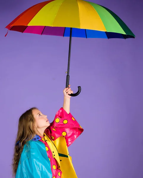 Wasserfestes Zubehör für Kinder. Mädchen glücklich halten bunten Regenschirm tragen wasserdichten Mantel. Regenwetter mit passender Kleidung genießen. wasserdichtes Zubehör macht Regentag fröhlich und angenehm — Stockfoto