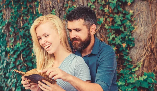 Romantic couple holds old book with poems about love.