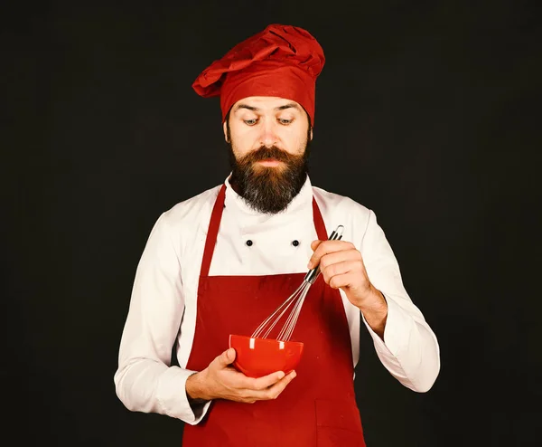 Man of hipster met baard houdt keukengerei op zwarte achtergrond — Stockfoto