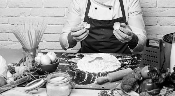 Szakács teszi a tésztát. Férfi kezében tartsa törött tojás-kagyló — Stock Fotó