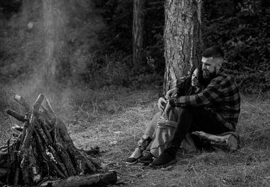 Kadınlı bir adam sarılıyor ve şenlik ateşinin yanında ısınıyor..