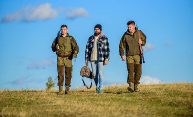 Çocuklar için avcılık toplandı. Erkek av tüfekleri taşırlar. Avcılar silahlı güneşli sonbahar gün yürür, yürür. Hobi ve eğlence avcılık. Acımasız hobi. Grup erkek avcılar veya gamekeepers doğa arka plan mavi gökyüzü