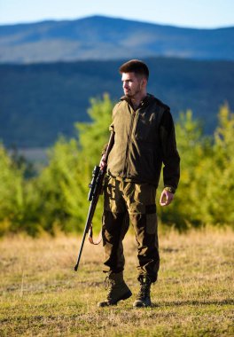 Bireysel işlem avcılık zihinsel hazırlığı. Adam tüfek av için. Avcı haki elbise avlamak hazır silah Dağları arka plan tutun. Avcı tüfeği hayvan için arıyorum. Avcılık atıcılık kupa