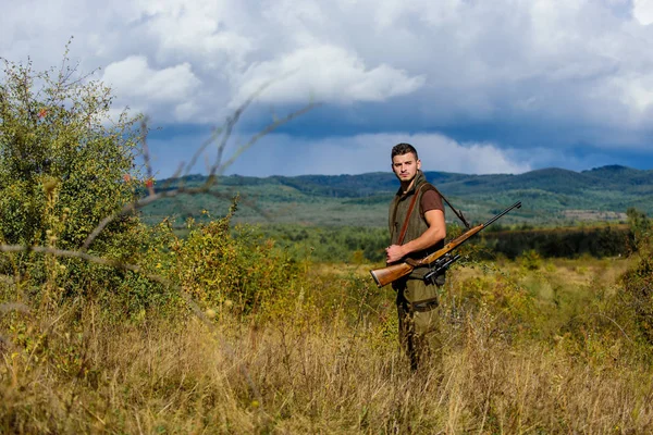 人肌肉发达残酷的家伙猎场管理员自然背景。亨特步枪站在山顶上。男胡子猎人花休闲狩猎鸟类。狩猎爱好的概念。狩猎的规定 — 图库照片