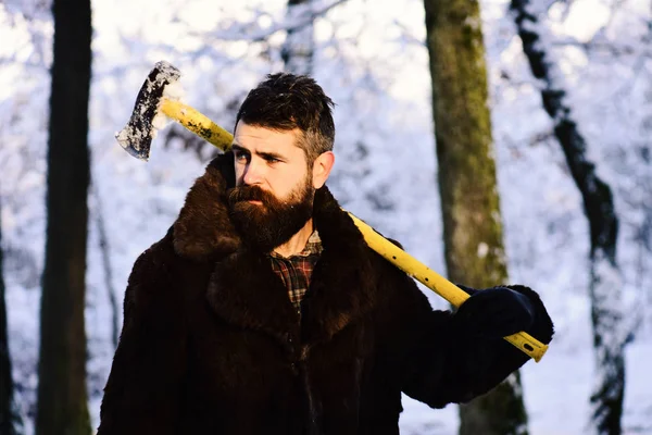 Macho med skägg och mustasch håller gul yxa. — Stockfoto