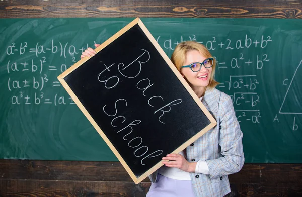 Super début d'année scolaire. Meilleures façons d'accueillir les élèves à l'école. La maîtresse garde l'inscription au tableau noir à l'école. Professeur d'école heureux élèves bienvenus. C'est l'heure de l'école agai — Photo