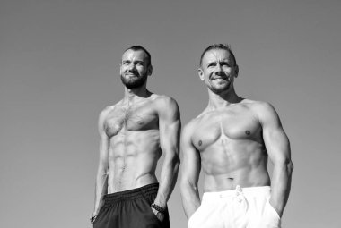 Erkekler kas vücut güvenle ile poz ceplerinde eller. Sporcular kas poz göbek. Spor ve welness. Kaslı erkek çocuklar rahat görünüyor. Erkekler seksi kaslı çıplak gövde stand açık