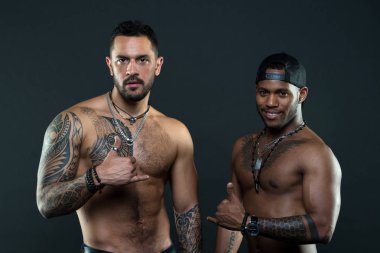 Samimi niyet asmak gevşek jesti bilinen Shaka işareti. Afrika İspanyol erkekler seksi çıplak gövde. Erkek dövmeli vücut uygun. Dövmeli manken shaka hareketini göster. Seksi çocuklar koyu arka plan asmak.