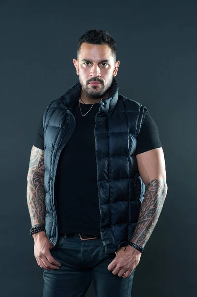 Bearded man posing with tattoos. Macho unshaven brutal wear vest. Masculinity and fashion concept. Tattoo brutal attribute. Tattoo art concept. Man brutal unshaven hispanic appearance tattooed arms