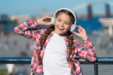 Müzik ailesi aboneliğini al. Milyonlarca şarkıya erişim. Dinlemeyi hak eden en iyi müzik uygulamaları. Kız çocuk açık havada modern kulaklıklarla müzik dinler. Bedavaya dinle. Müzik herhangi bir yerde