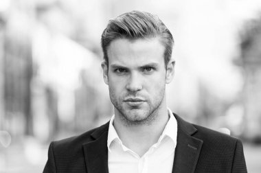 Genç ve başarılı. İşadamı yakışıklı çekici office çalışan emin yüz. Bakımlı zarif resmi takım elbise defocused kentsel arka plan yürür. İşadamı ciddi yürüyüş sırasında öğle yemeği zamanı