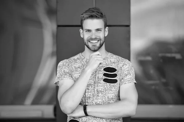 Homme heureux avec barbe sur le visage souriant en plein air. Macho sourire en tshirt gris. Décontracté dans le style. Heureux et en bonne santé. Un beau garçon sportif. Confiance et charisme — Photo