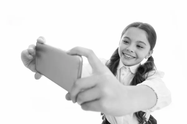 Lassen Sie mich ein Selfie machen. Mädchen niedlichen langen lockigen Haaren hält Smartphone Selfie weißen Hintergrund. Schuluniform für Mädchen hält Smartphone in der Hand. Schuluniform smart kid happy face — Stockfoto