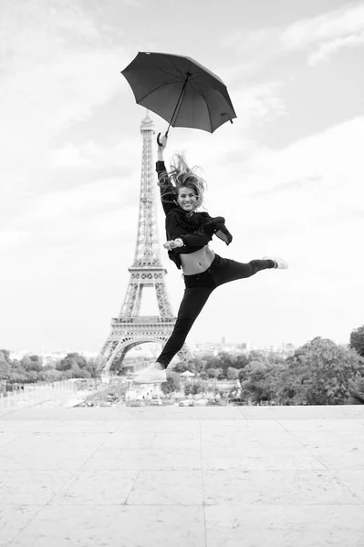 Fashion woman jump with umbrella. Happy woman travel in paris, france. Girl with beauty look at eiffel tower. Travelling and wanderlust. Parisian isolated on white background. Enjoy summer vacation