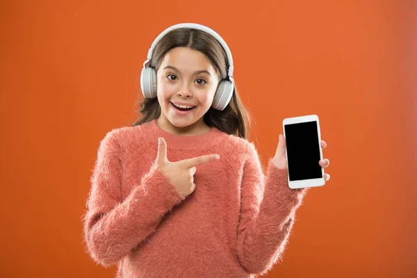 Najlepsze aplikacje muzyczne, które zasługują na słuchać. Dziecko dziewczynka słuchać muzyki nowoczesne słuchawki i smartphone. Słuchaj za darmo. Pobierz muzyka subskrypcja dla rodzin z dziećmi. Dostęp do milionów utworów. Ciesz się koncepcja muzyki — Zdjęcie stockowe