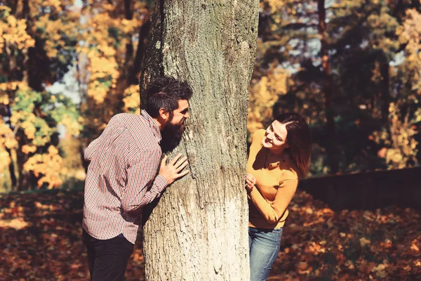 Para zakochanych odgrywa za drzewa w parku jesień. — Zdjęcie stockowe