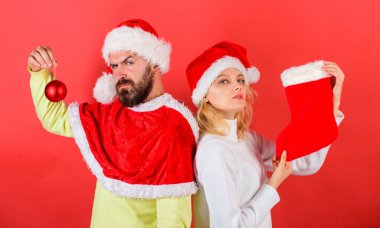 Kadın ve santa şapka Noel kırmızı arka plan bekleyen sakallı adam. Noel kutlamaları kavramı. Noel çorap geleneği. Çift Noel Noel Baba kostüm tutun çorap ve süsleme top