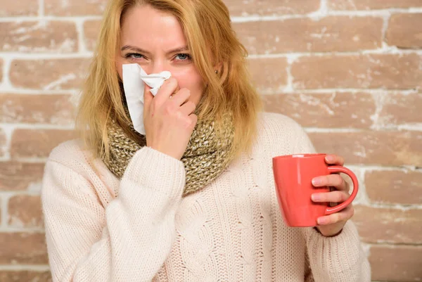 Remédios para resfriados e gripe. Remédios devem ajudar a vencer o frio rápido. Dicas como se livrar do frio. A mulher sente-se mal a espirrar. Menina em cachecol segurar caneca de chá e tecido. Nariz escorrendo e outros sintomas de frio — Fotografia de Stock