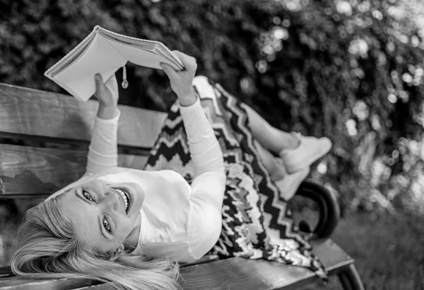 Dame visage heureux profiter de la lecture. Il est temps de s'améliorer. Fille reposer banc parc détente avec livre, fond vert de la nature. Femme passer du temps libre avec le livre. Fille lecture en plein air tout en se relaxant sur le banc — Photo