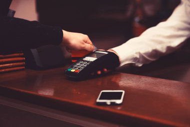 Kredi kartı ile ödeme. Erkek el bankcard okuyucu koyar.