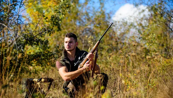 Habilidades e estratégia de caça. Estratégia de caça ou método para localizar o alvo e matar o animal alvo. O homem que caça espera pelo animal. Caçador com rifle pronto para caçar fundo natureza — Fotografia de Stock