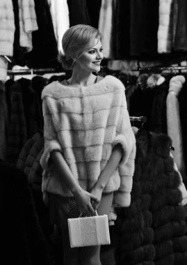 Bayan beyaz çanta kürk dükkanda tutar. Kış giyim kavramı.