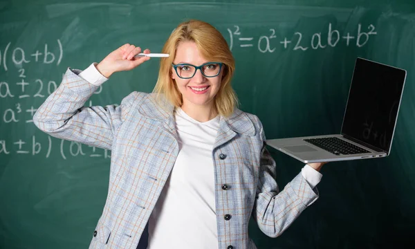 Idea on her mind. Digital technologies concept. Woman teacher wear eyeglasses holds laptop surfing internet. Educator smart clever lady with modern laptop surfing internet chalkboard background — Stock Photo, Image