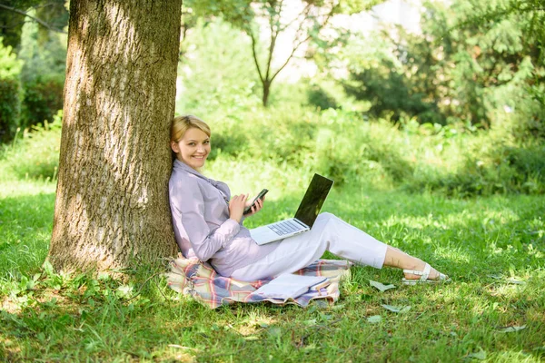 Используйте возможности цифровых технологий. Женщина с ноутбуком и смартфоном работает на открытом воздухе. Современные технологии дают больше возможностей для реализации своего потенциала. Девушки используют современные технологии для бизнеса — стоковое фото