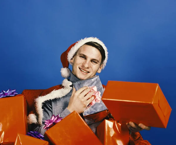 Man holds xmas presents. Santa with gifts on blue background