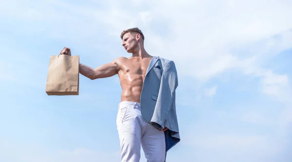 Chico atractivo macho llevar bolsa de compras hecha de papel marrón. Temporada de ventas. Productos ecológicos saludables. Hombre atleta muscular mantenga bolsa de compras fondo cielo. Venta caliente y descuento. Toma este paquete. — Foto de Stock