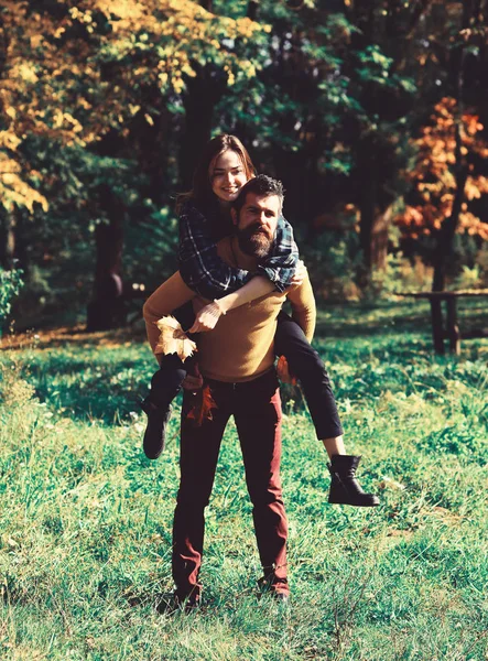 Счастливая пара в осеннем парке. Молодая семья веселится на открытом воздухе — стоковое фото