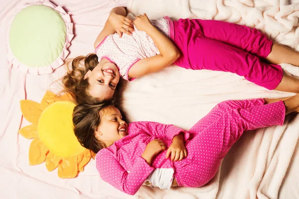 Children with happy faces lie close on pink blanket background. — Stock Photo, Image