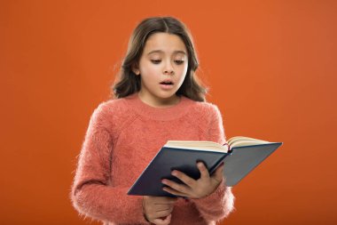 Çocuklar için okuma alıştırması. Çocuk edebiyatı. Kız tutun kitap turuncu arka plan üzerinde hikaye okuyun. Çocuk kitap okuma keyfini çıkarın. Kitap mağaza konsepti. Harika ücretsiz çocuk kitapları okumak için
