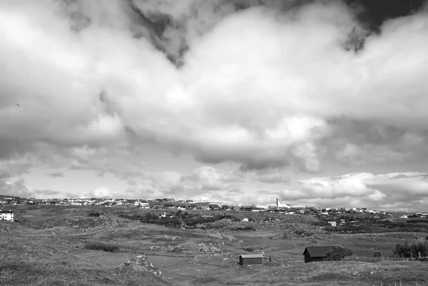 Paisaje rural con casas rurales bajo el cielo nublado en Torshavn, Dinamarca. Hermosa vista del paisaje. Terreno montañoso con hierba verde. Cielo nublado. Naturaleza y medio ambiente. Vacaciones de verano en el campo —  Fotos de Stock