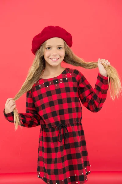 Miúda menina bonito com cabelos longos posando em chapéu fundo vermelho. Como usar boina francesa. Inspiração de estilo boina. Acessório de boina na moda de mulher. Como usar boina como menina da moda — Fotografia de Stock